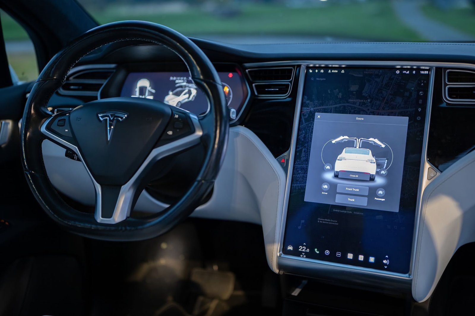 Futuristic autonomous vehicle interior with a touchscreen interface displaying a ride-sharing map and partnership logos, seen from the backseat of a moving robotaxi.