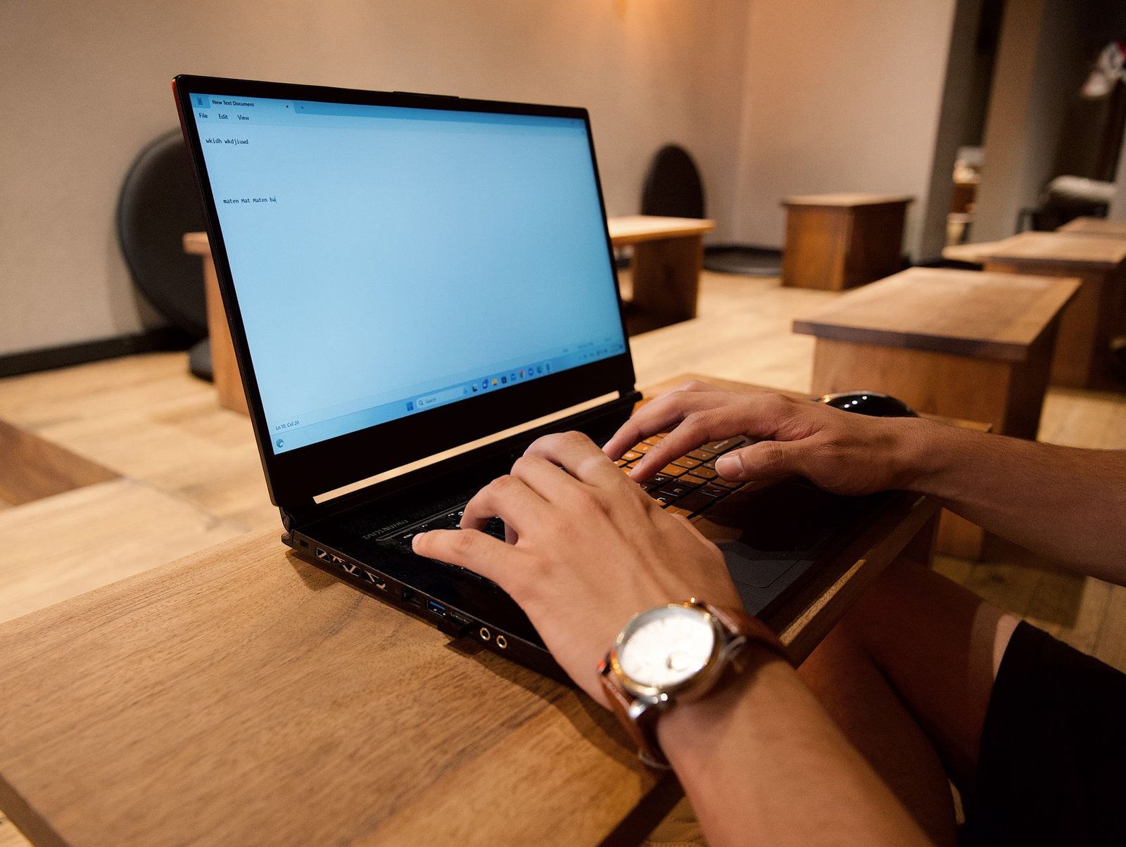 Close‑up of a Wi‑Fi 7 configured laptop showing ultra‑fast throughput graphs on screen, with a wireless access point in the background