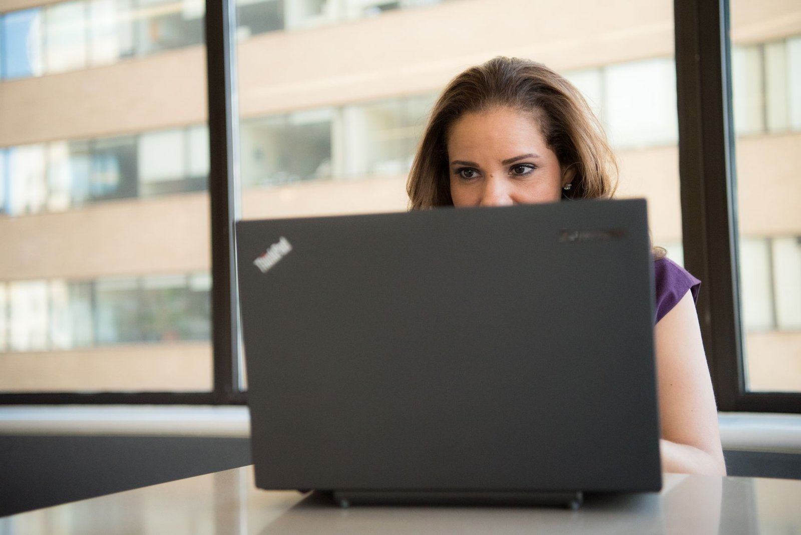 Businesswoman configuring Salesforce Agentforce AI agent on a laptop, with dashboard displaying autonomous task completion and flow logic