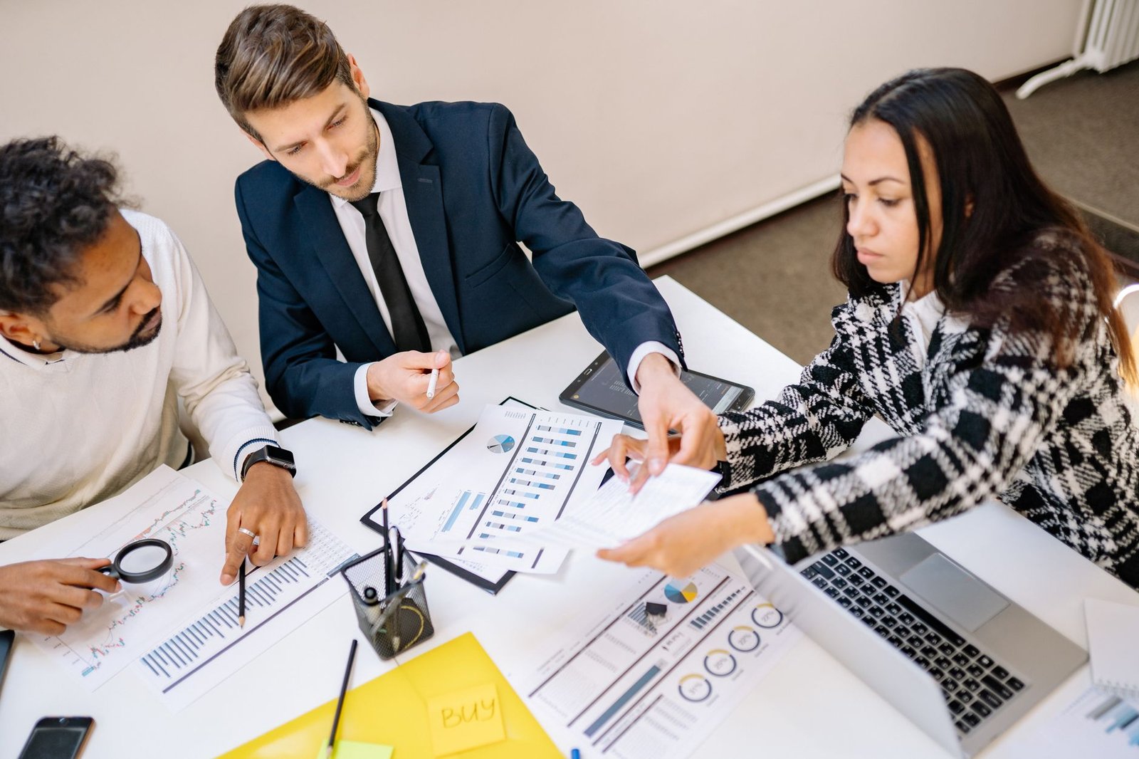 A boardroom table with laptops, tablets, and documents, representing enterprise decision-making about technology adoption.