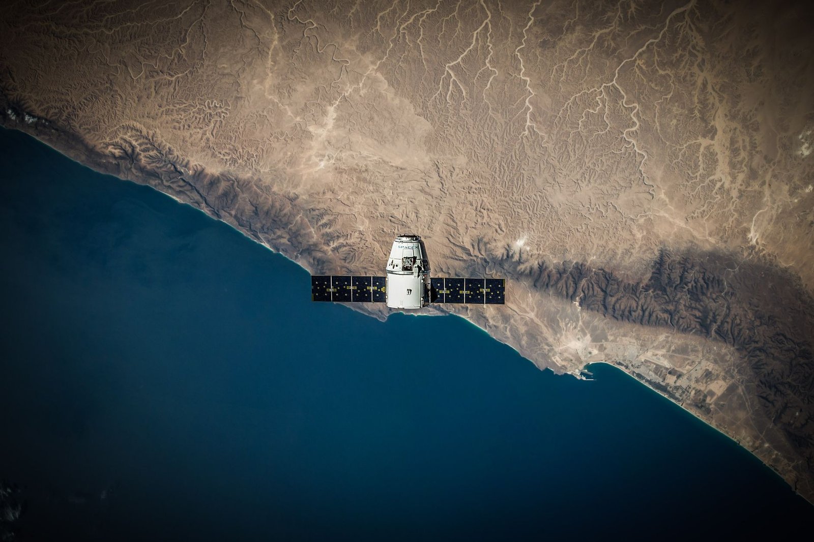Artistic rendering of a small data center module in low Earth orbit, glowing blue with solar panels extended, Earth’s curvature in the background