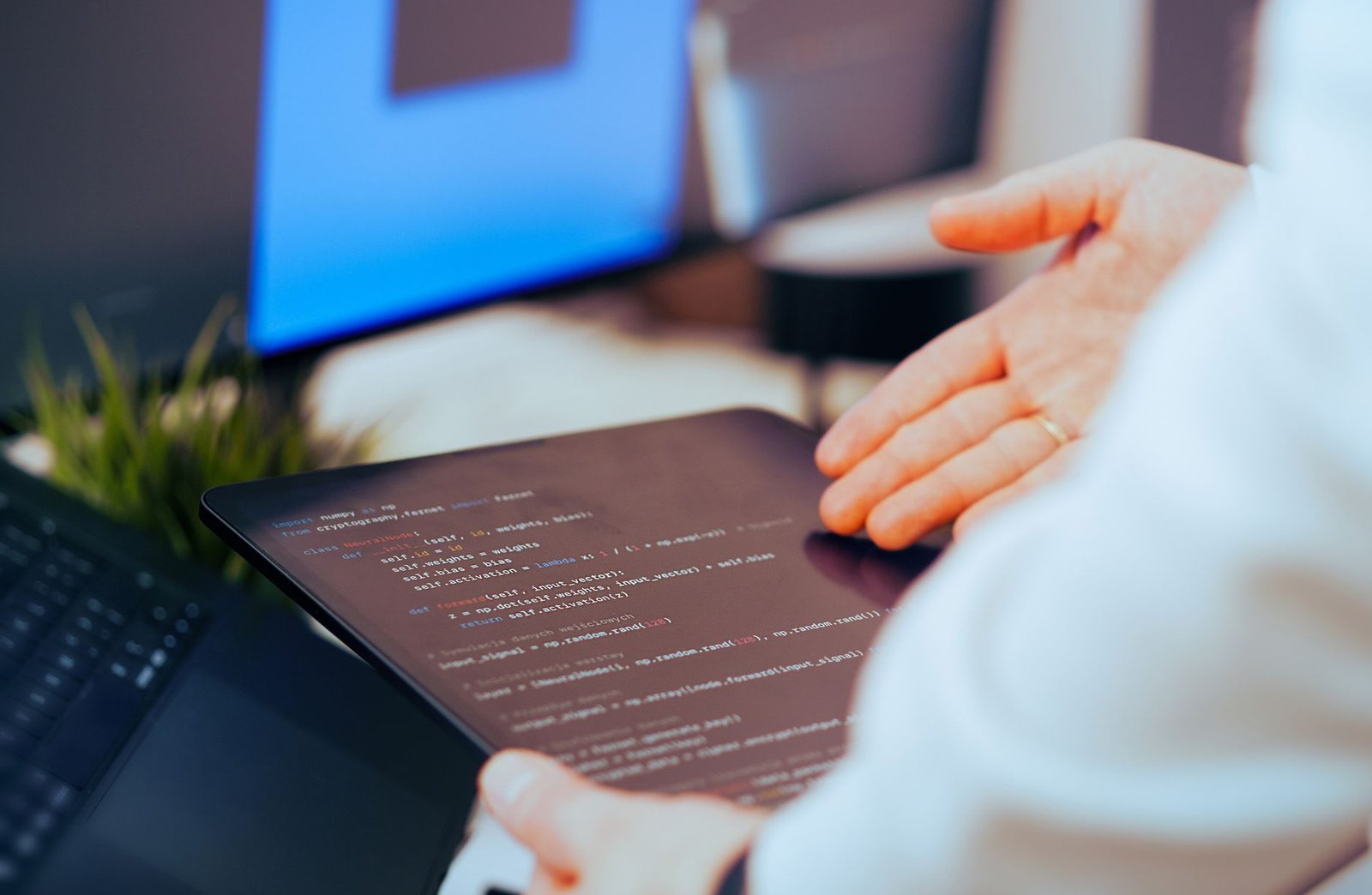 Software engineering team gathered around a large monitor reviewing code and AI-generated outputs in a modern tech office