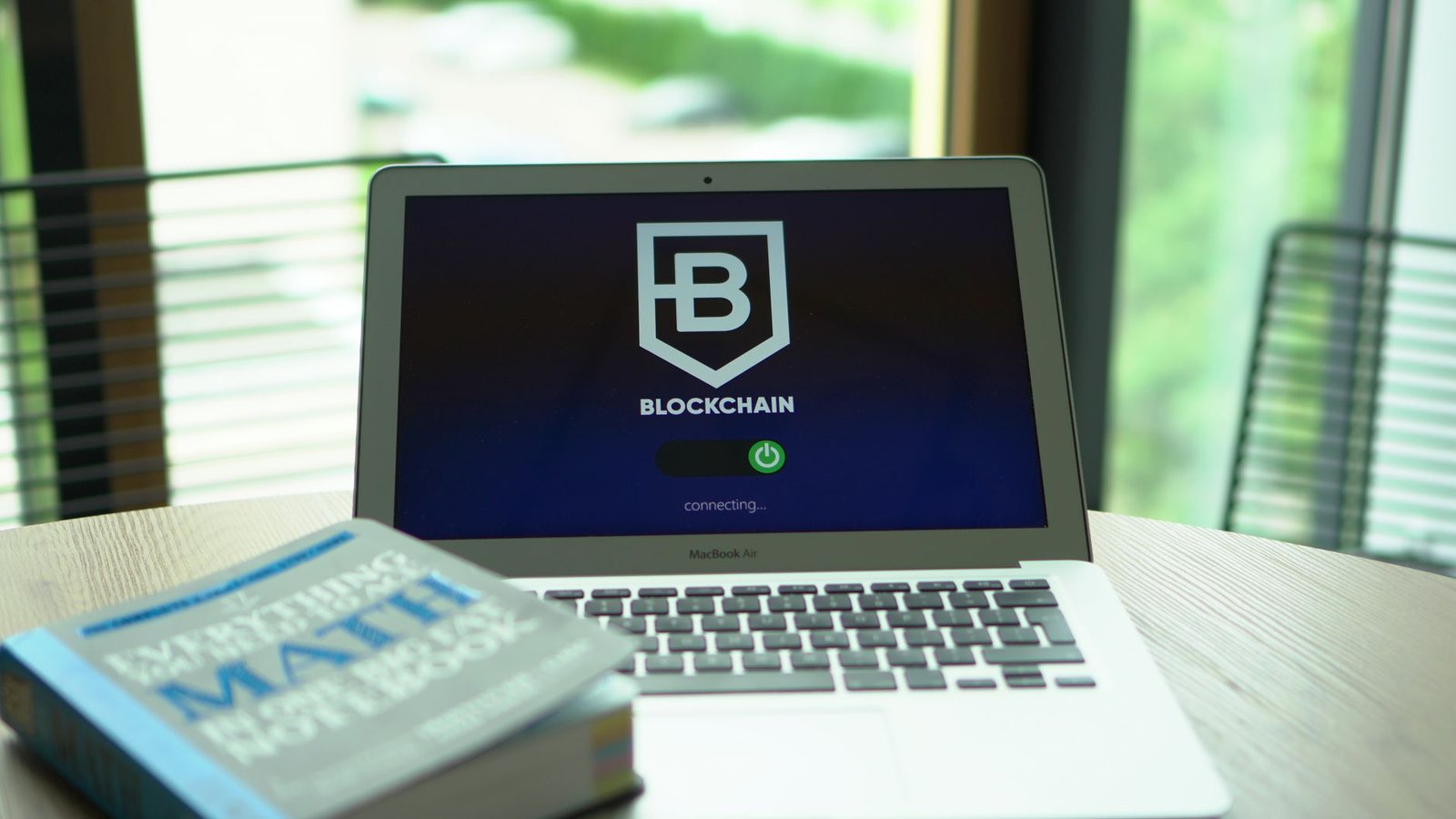 Software developer looking at lines of code on a monitor while an overlay shows a blockchain ledger of document hashes