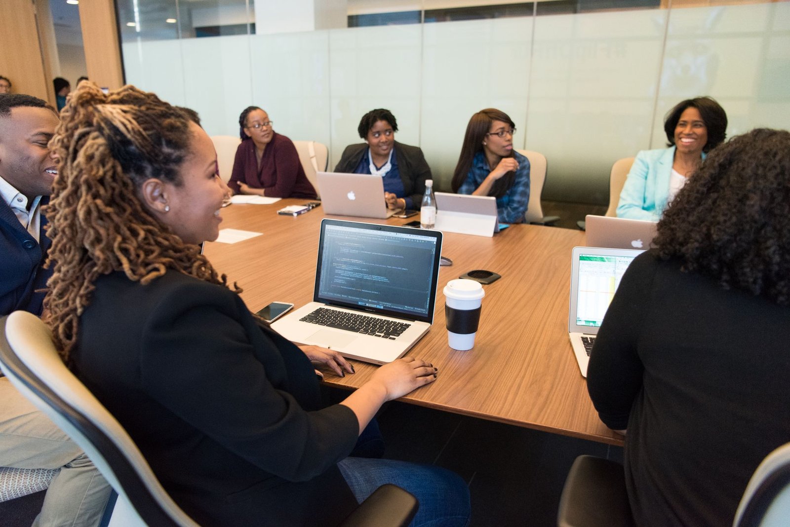 Business professionals in a boardroom looking at a large screen showing blockchain and document management diagrams