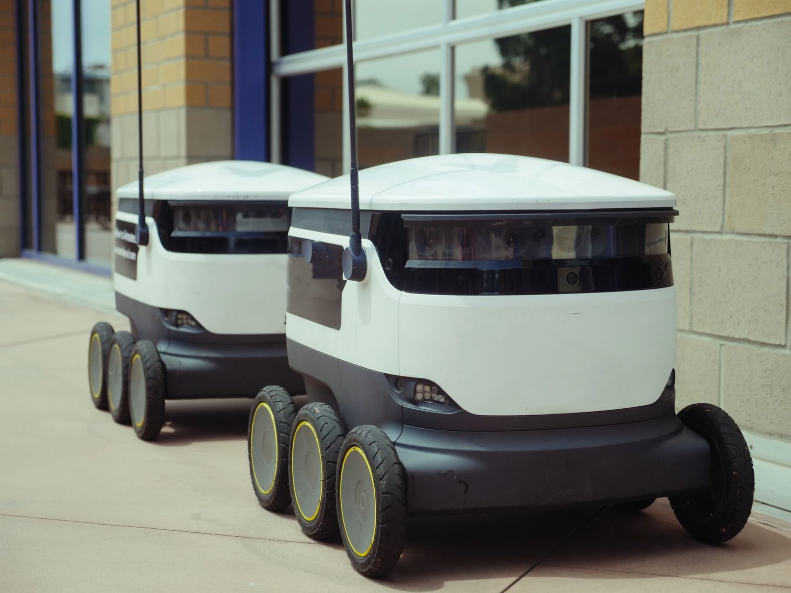 An engineer using a tablet to monitor a fleet of autonomous mobile robots in a smart warehouse