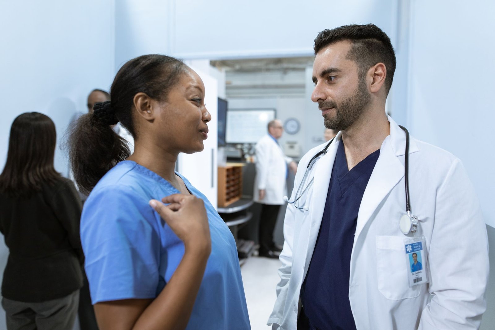 Doctor and IT professional reviewing healthcare data on a large digital screen in a modern hospital setting