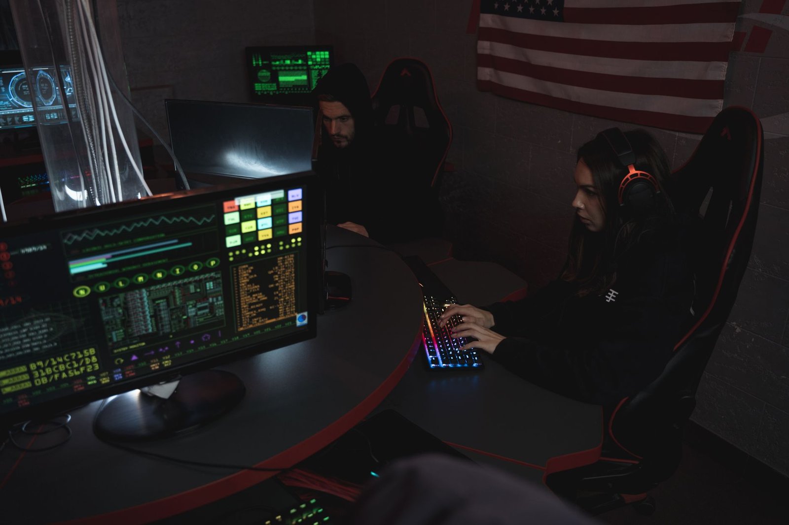 A software developer analyzing server data on multiple monitors with government security badges visible