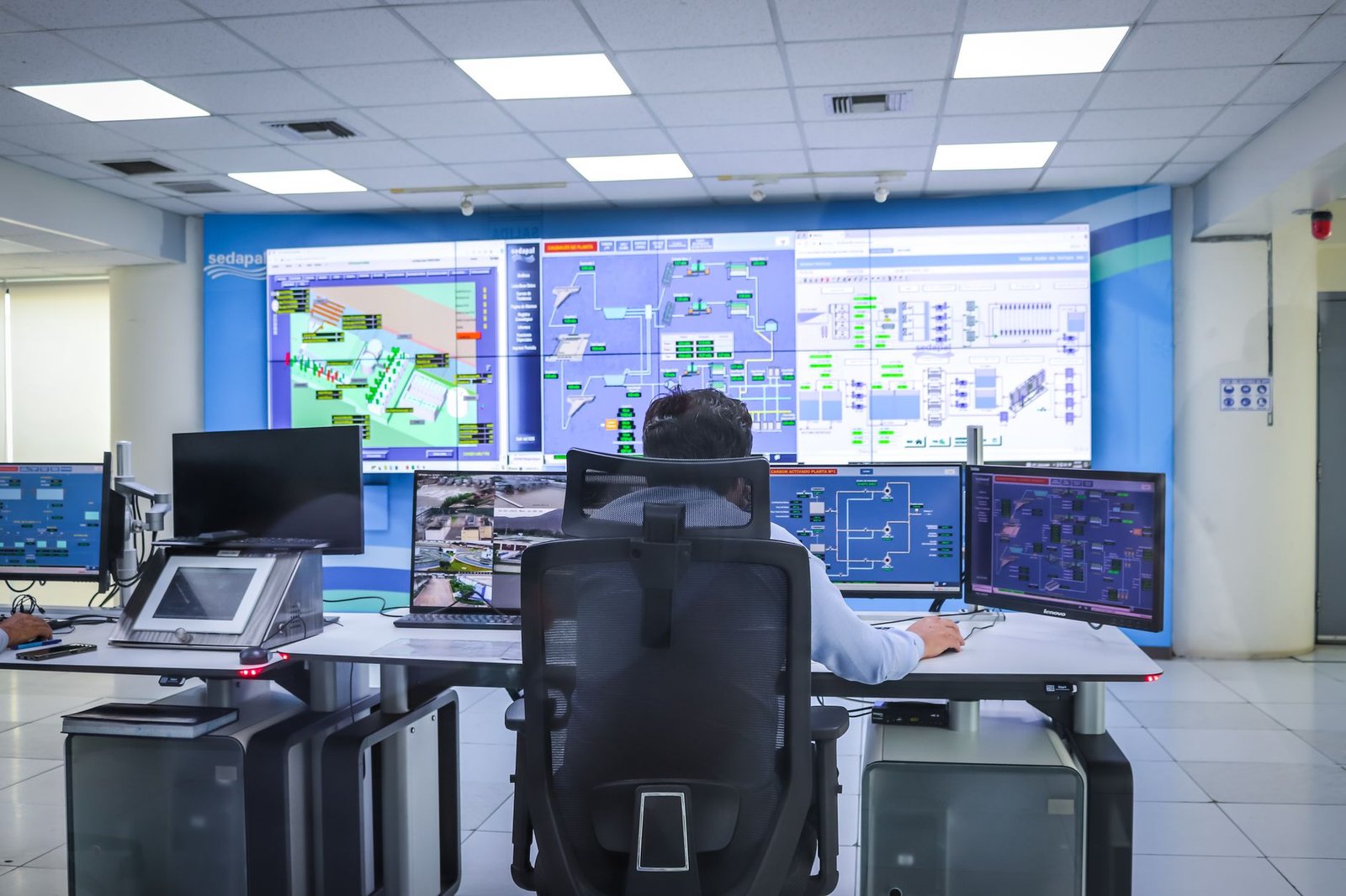 Industrial control system panel with digital SCADA screens and blinking lights in a modern power plant control room