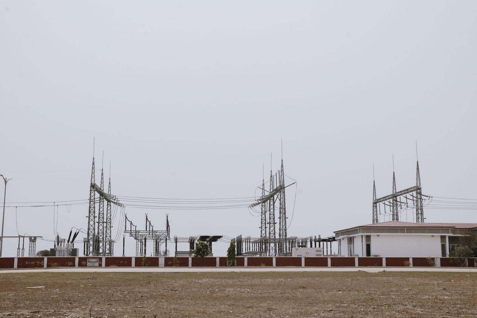 Aerial view of a power substation with electrical towers against a sunset sky, emphasizing critical infrastructure